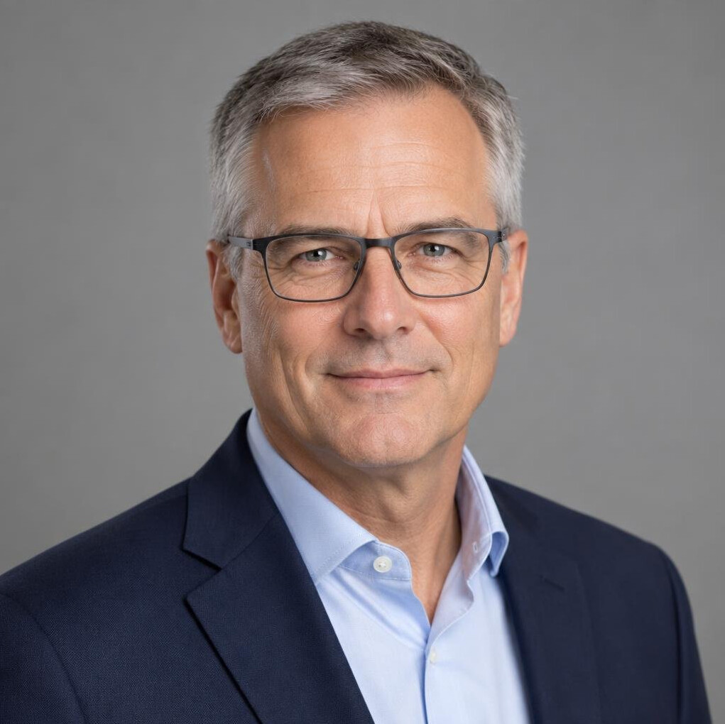 Studio portrait of a man in his 50s with glasses and grey hair
